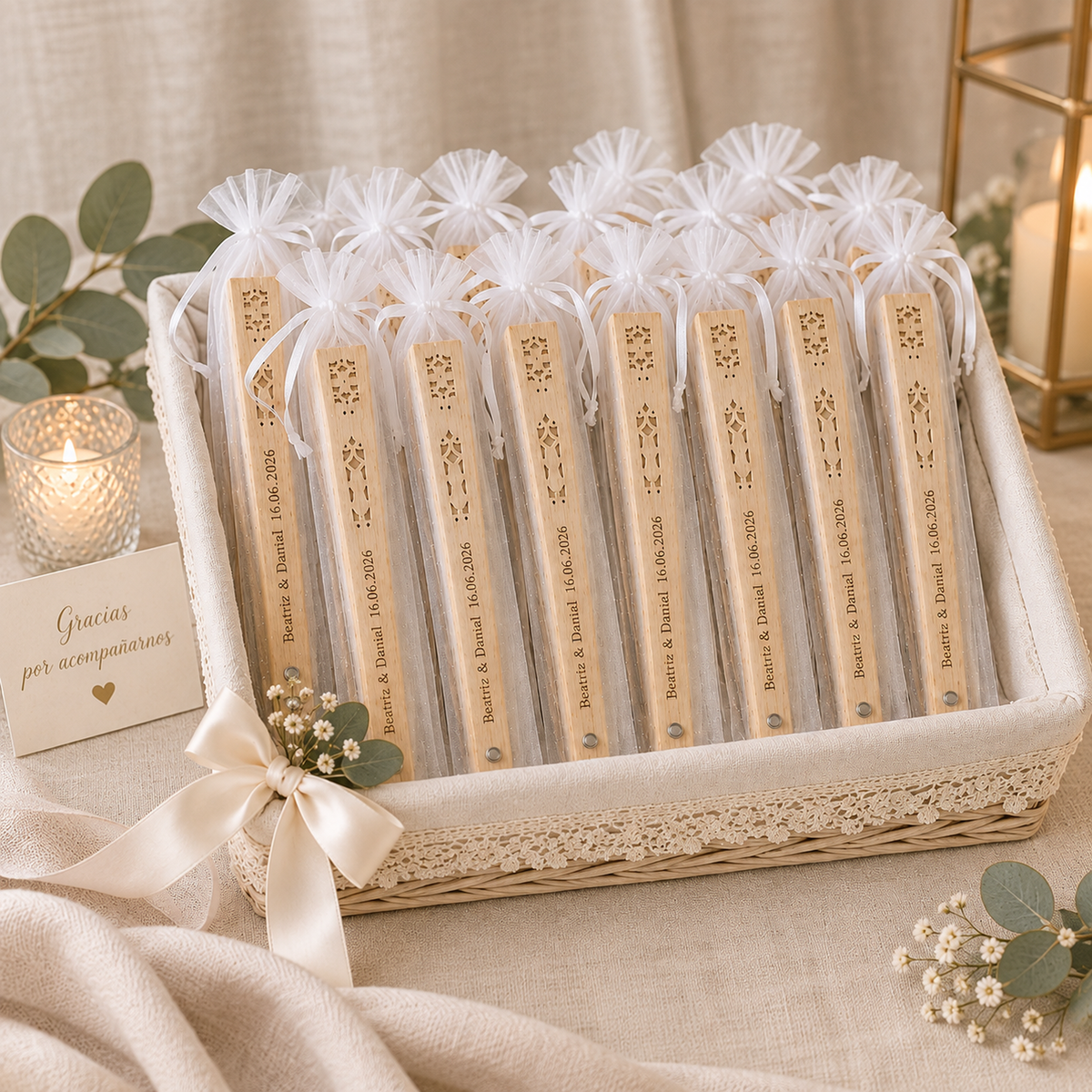 Cesta con abanicos de madera grabados y personalizados para boda, envueltos en bolsas de organza blanca con nombres y fecha grabados